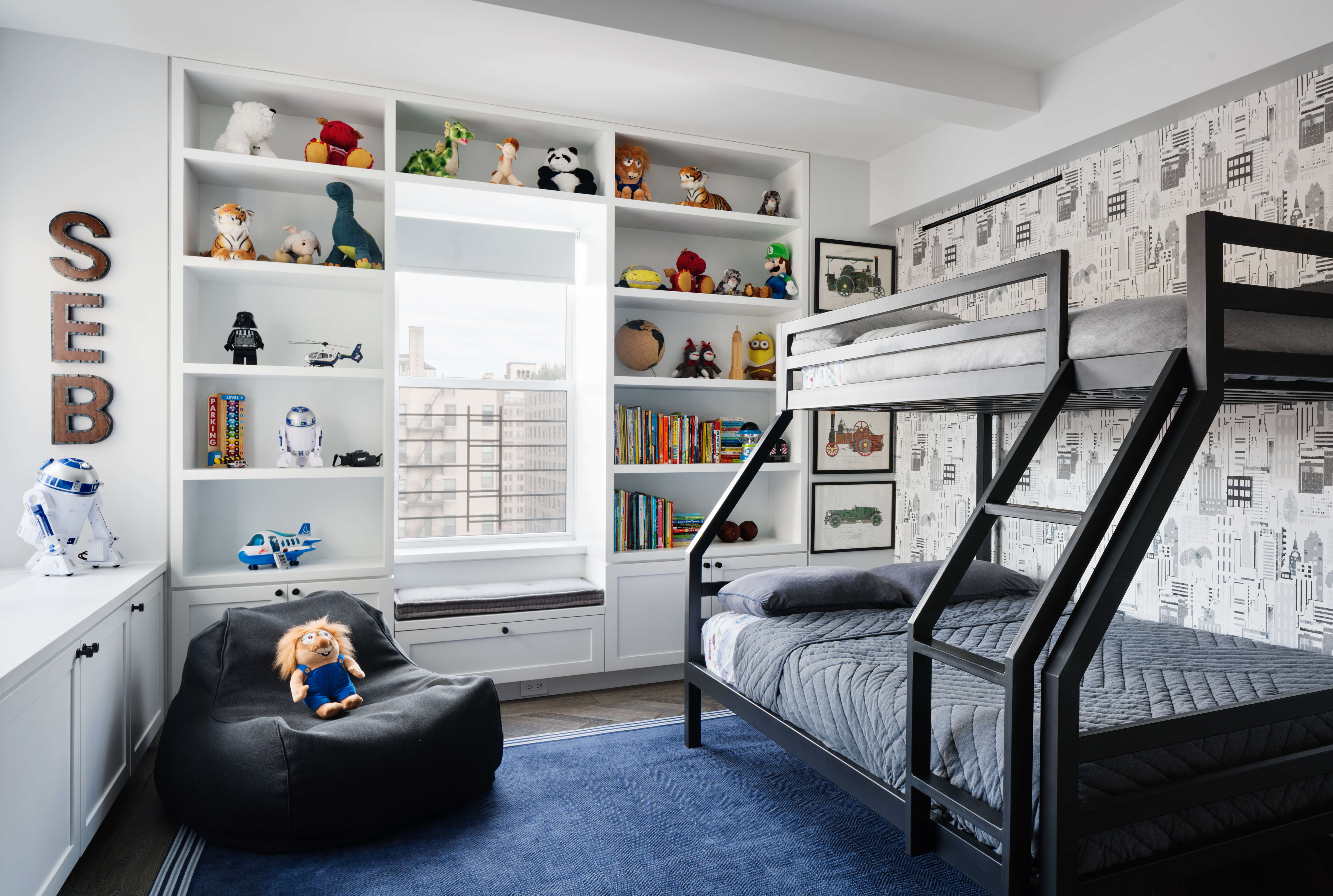 A boys bedroom with built-in cabinets around the window.