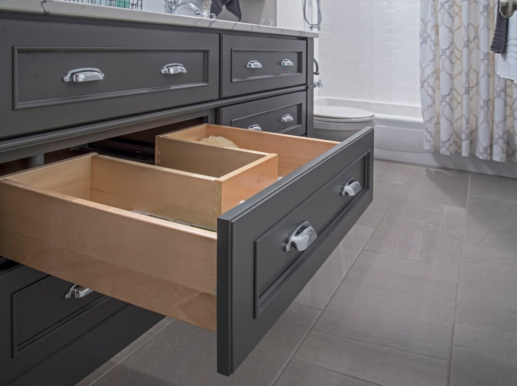 A plumbing drawer in a dark gray painted vanity.