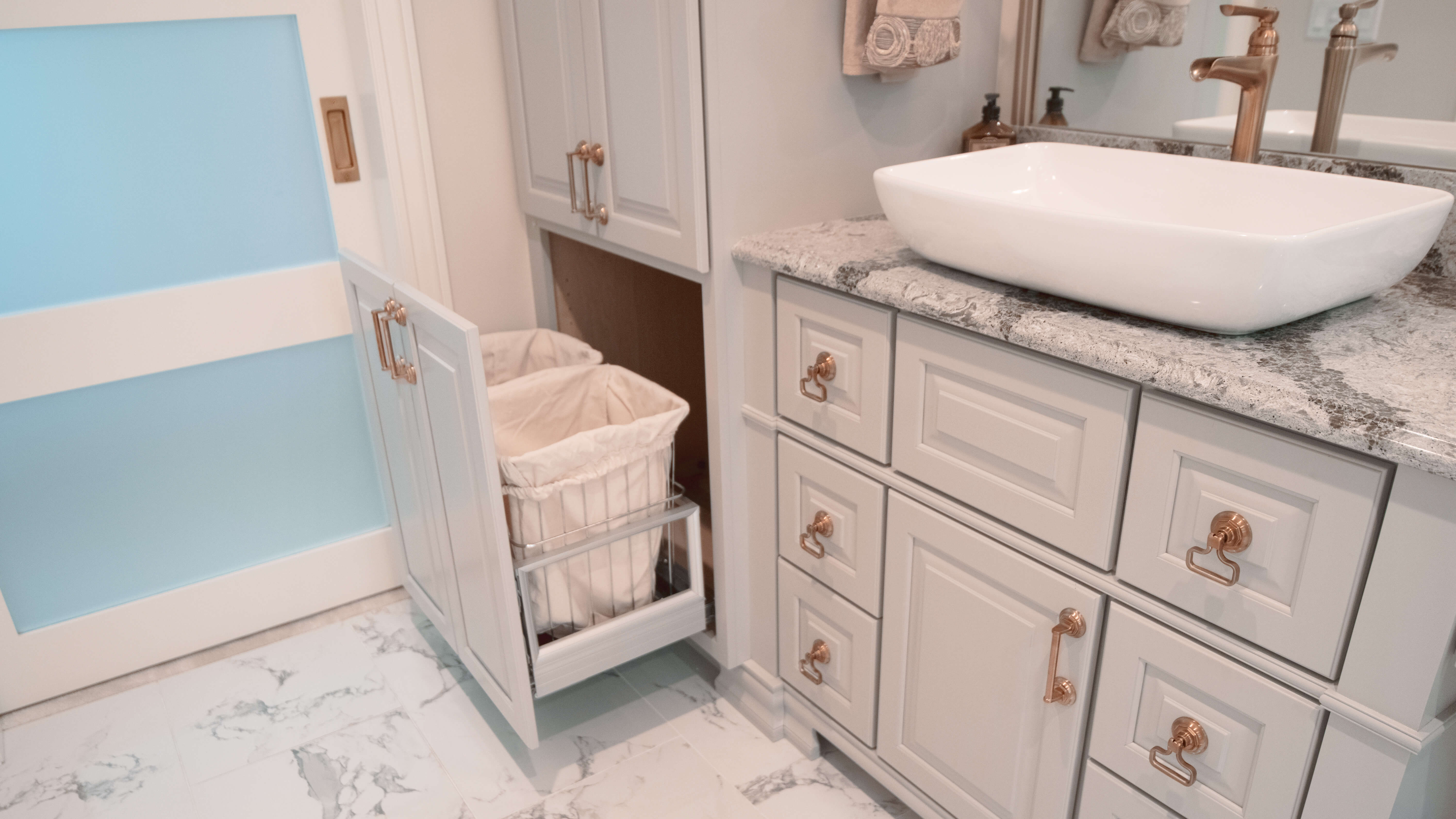 A pull-out hamper cabinet in a painted vanity.
