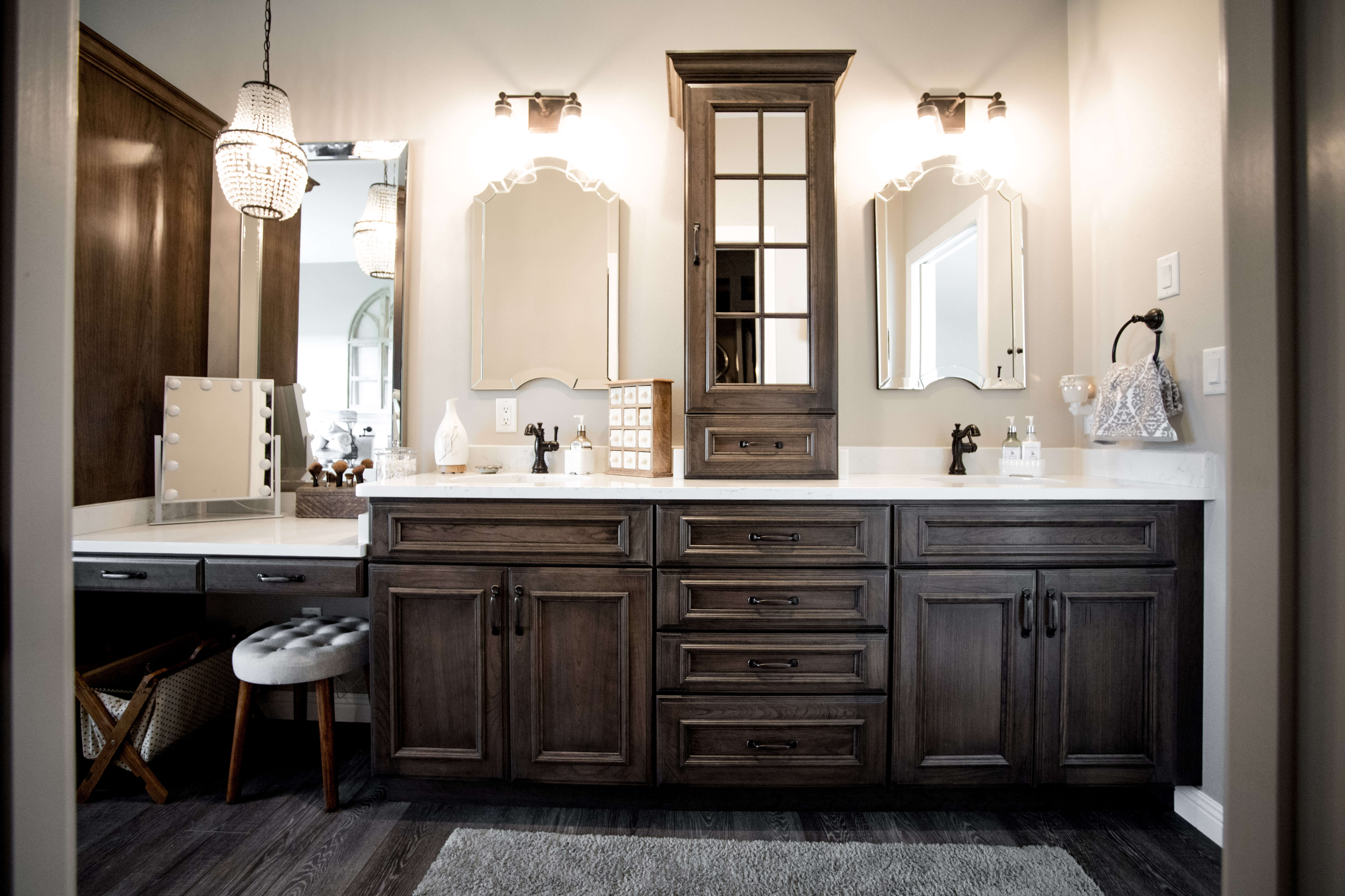 A dark rustic bathroom vanity with double sinks and tower in the middle.
