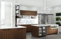 A city loft is remodeled with an angled kitchen island with black metal framed cabinet doors and walnut veneer cabinets.