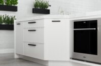 A white painted kitchen island in a modern kitchen with a skinny shaker door style.