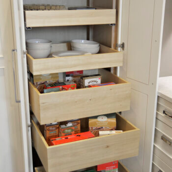 A tall kitchen pantry cabinet with roll-out shelves for easy and accessible storage for kitchen supplies and dry goods.