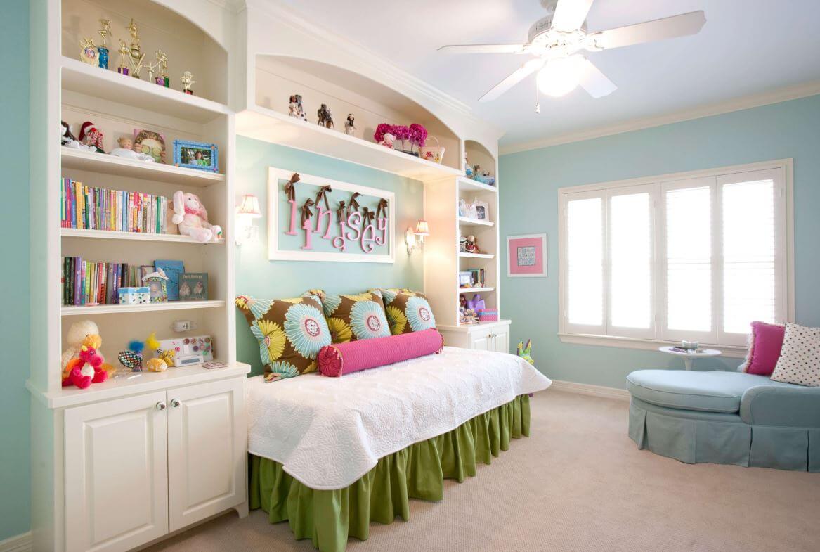 A girl's bedroom with built-in cabinets around the bed for extra storage.