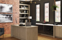 A home office desk with a free standing desk and l-shaped desk area behind with black acrylic cabinets and white oak cabinets.