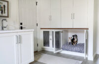 A laundry room with cabinets designed for dog beds with kennel like doors featuring a metal wire mesh cabinet insert.