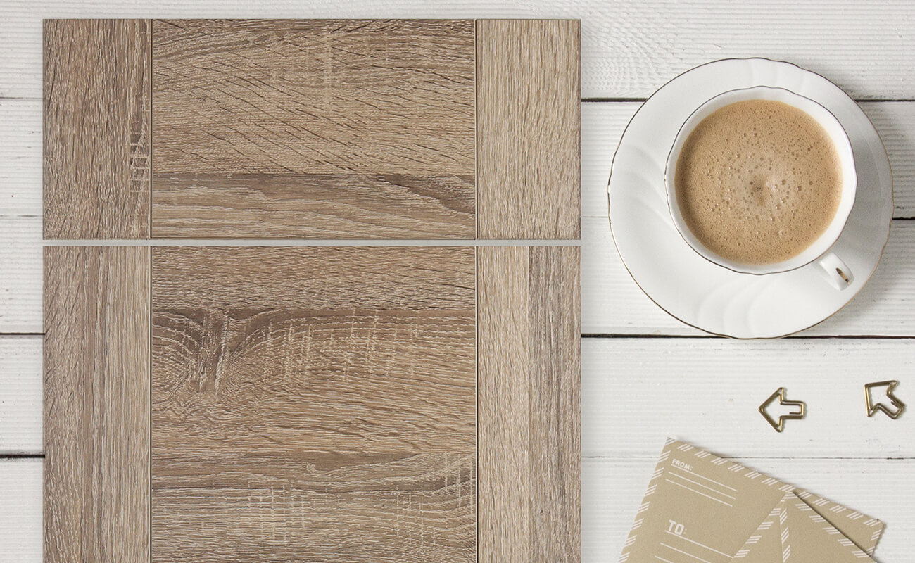 A close up of a three panel slab door style with a textured, rustic oak look.