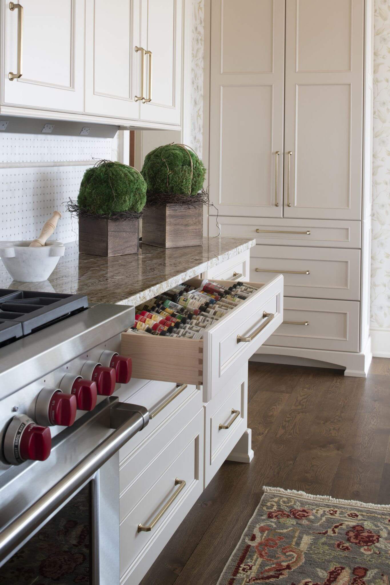 The drawer next to the stove and cooktop has a large spice rack for sorting and displaying a full spice collection.