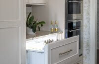 White painted cabinets with an appliance paneled beverage drawer.