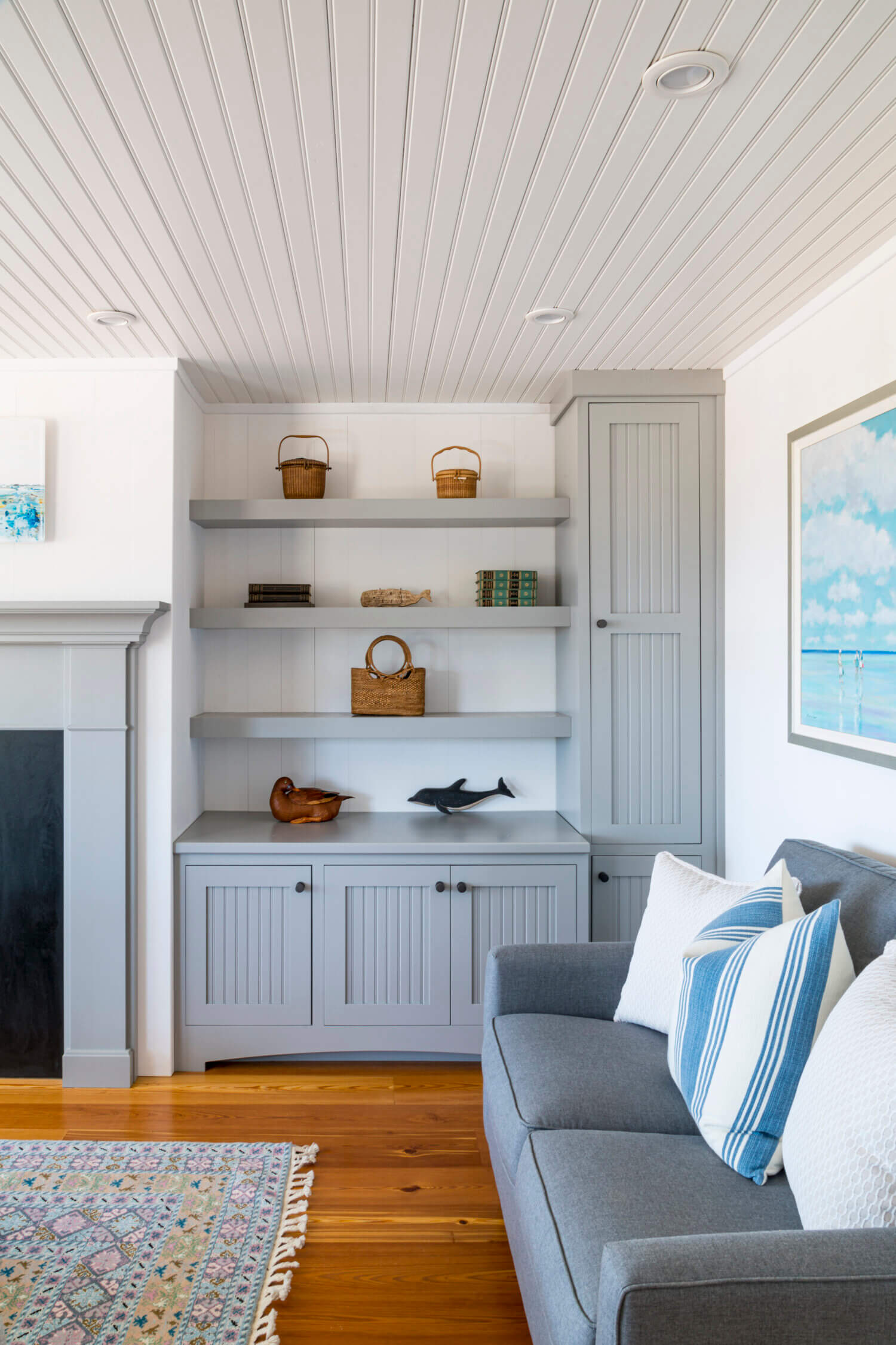 A gray painted built-in bookcase and cabinets match the fireplace mantel in this cottage style living room.