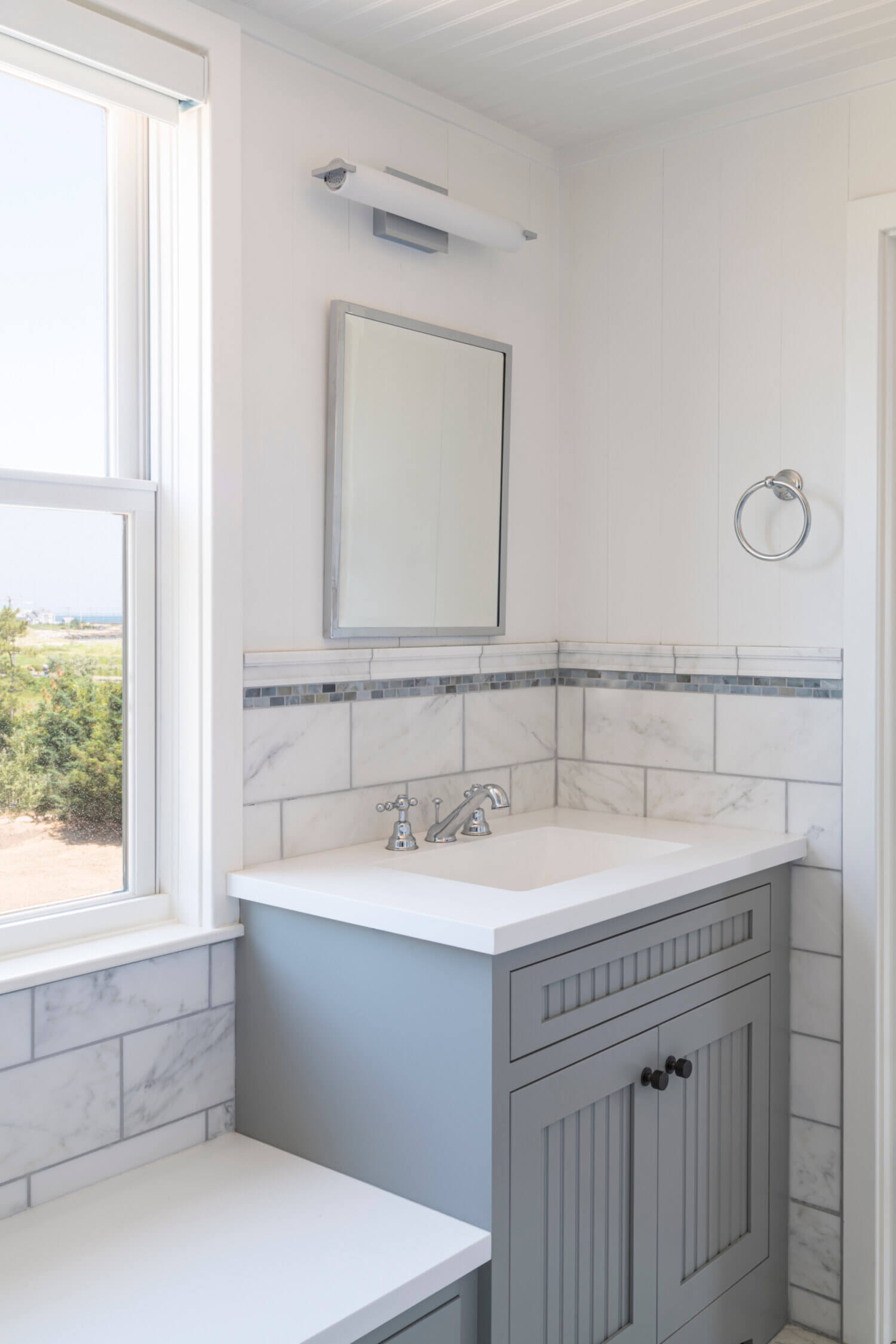 A gray painted sink vanity in a laundry room.