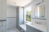 An all gray laundry room with a boot bench and locker.