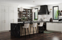 This kitchen design features a skinny shaker door style with thin rails and stiles using inset cabinets. The cabinetry colors combine matte back metal glass cabinet doors, with an off-white paint, and a light stained white oak.