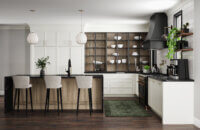 This alluring kitchen design features a skinny shaker door style with thin rails and stiles using inset cabinets. The cabinetry colors combine matte back metal glass cabinet doors, with an off-white paint, and a light stained white oak. A black painted curved hood creates a beautiful feature above the cooktop.