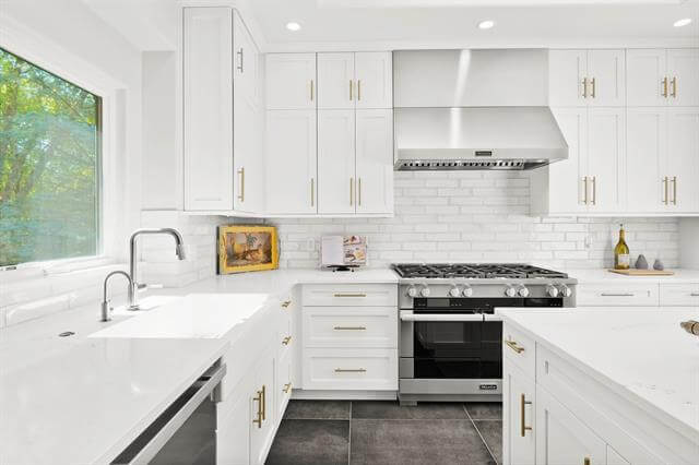 A crisp, bright white kitchen design with white painted shaker cabinets and stainless steel appliances.