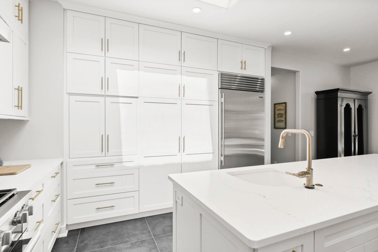 A wall of white painted shaker style cabinets in a transitional styled kitchen design.