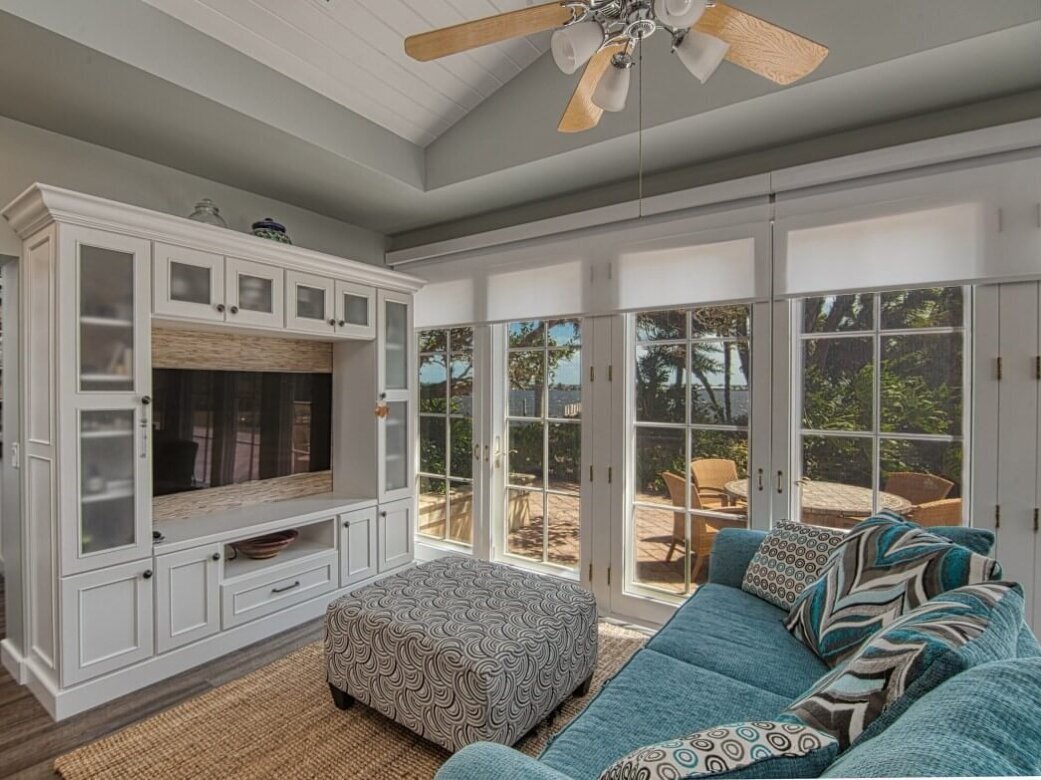 A pretty coastal living room with a built-in TV stand and media center with white painted cabinets from Dura Supreme.