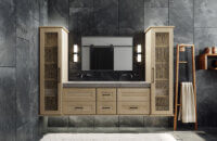 A floating vanity in a contemporary bathroom with a shallow shaker door style in a light raw quarter-sawn white oak color. Two tall floating linen cabinets flank each side of the vanity.