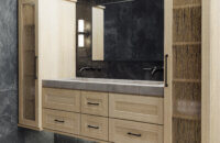 A floating vanity in a contemporary bathroom with a shallow shaker door style in a light raw quarter-sawn white oak color.