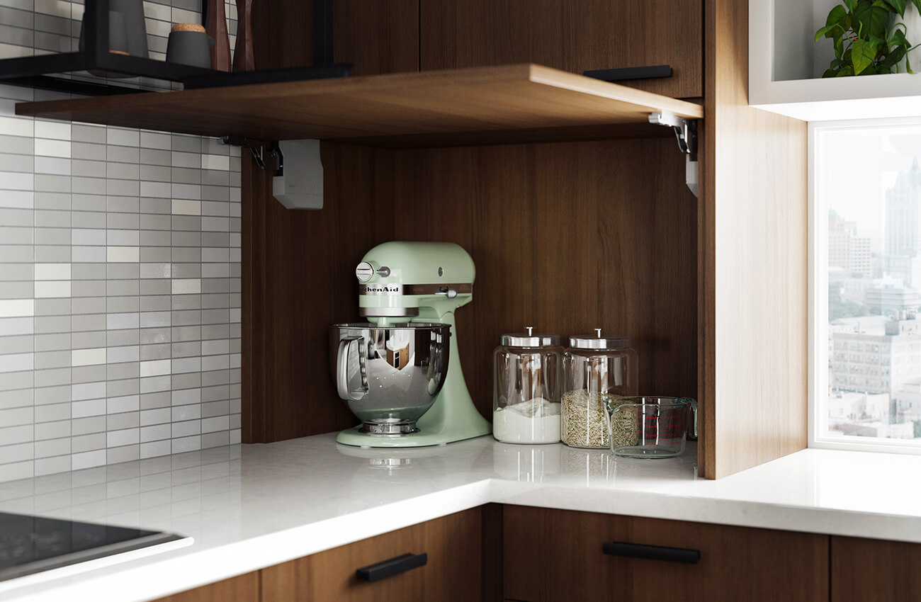 A counter-sitting cabinet in a modern city kitchen has a lift-up cabinet door that reveals the hidden small countertop appliances and supplies.