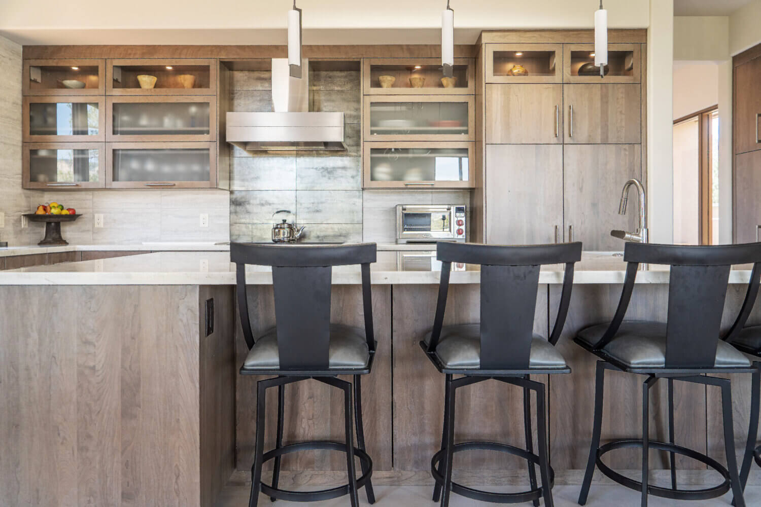 A close up of the contemporary kitchen island with bar stool seating.