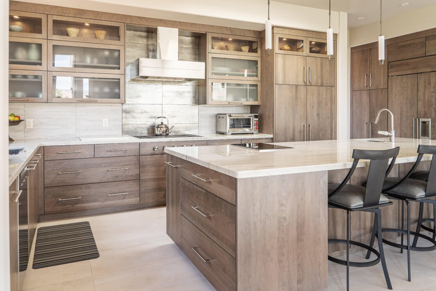 A soft contemporary frameless design featuring Cherry cabinets with the Camden slab door style from Dura Supreme Cabinetry.This modern kitchen is warm and inviting with is soft brown stained wood cabinets.