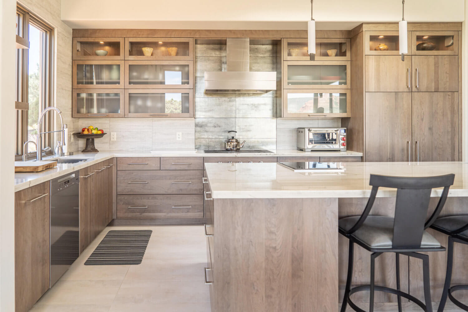 A contemporary kitchen design with gray-brown stained cabinets with slab styled doors.