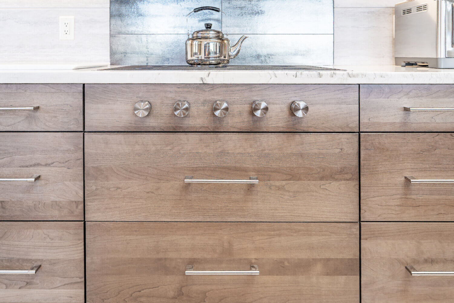 A close up of the flat, slab cabinet doors with a light gray-brown stain color.