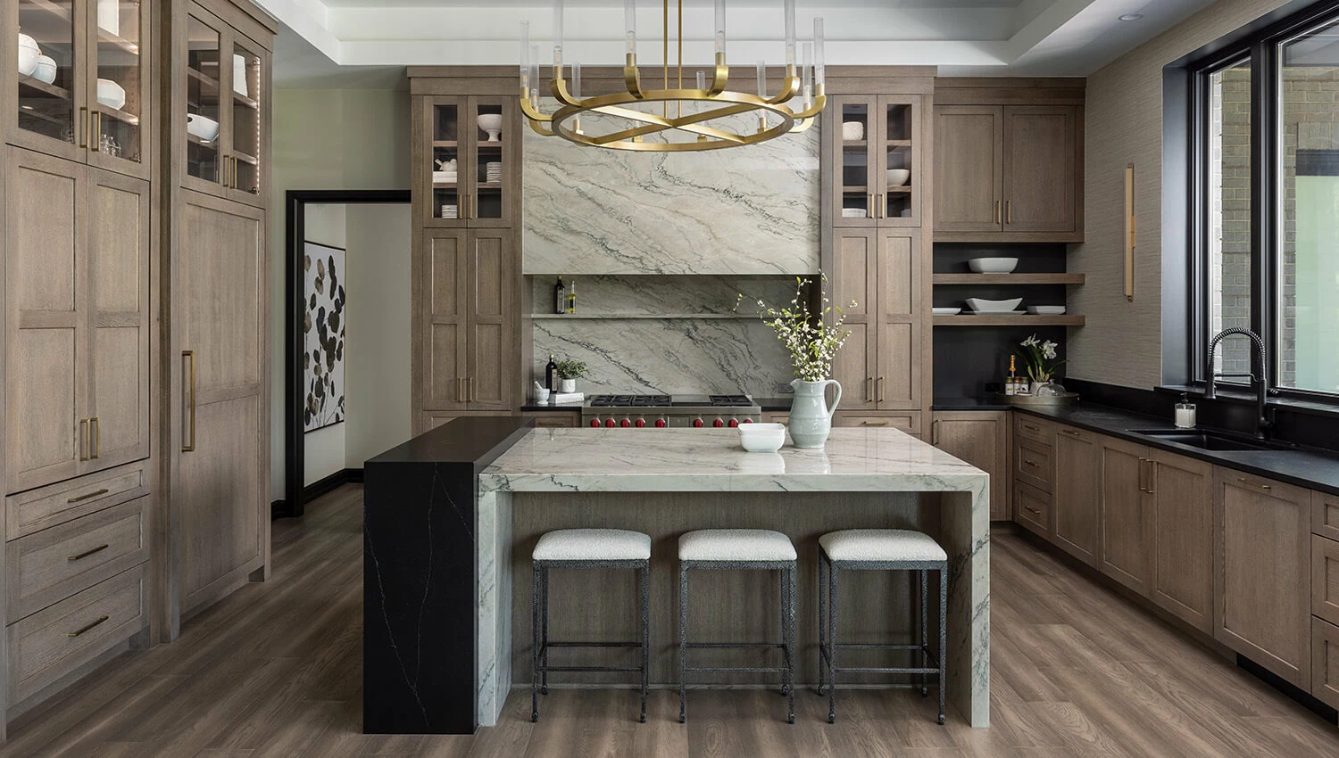 A Modern Prairie styled kitchen design by Sandra Daubenmeyer of KSI Kitchen & Bath, Michigan. The cabinets feature Dura Supreme's Carson door style in the Morel stain on Quarter-Sawn White Oak with accents of the Onyx stain on Maple. 
