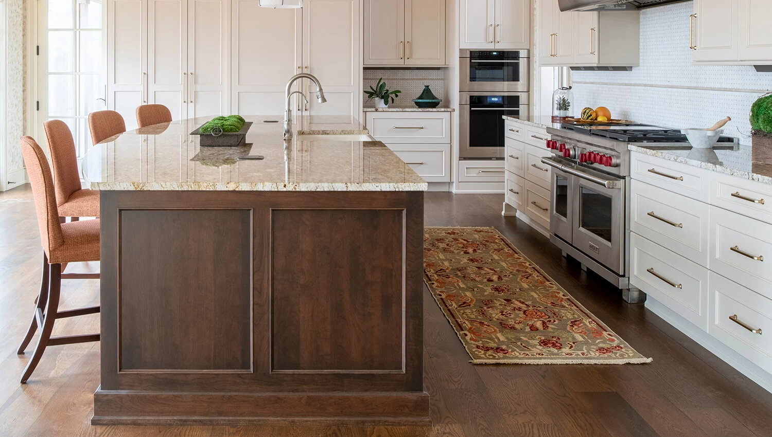 The kitchen island features a darker true-brown stain, Mocha on Cherry wood that beautifully contrasts the off-white perimeter cabinets shown in a Personal Paint Match to Benjamin Moore's Muslin paint color. 