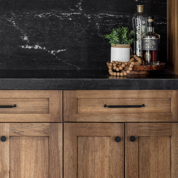 A close up of trendy, true-brown stained cabinets on Hickory wood.