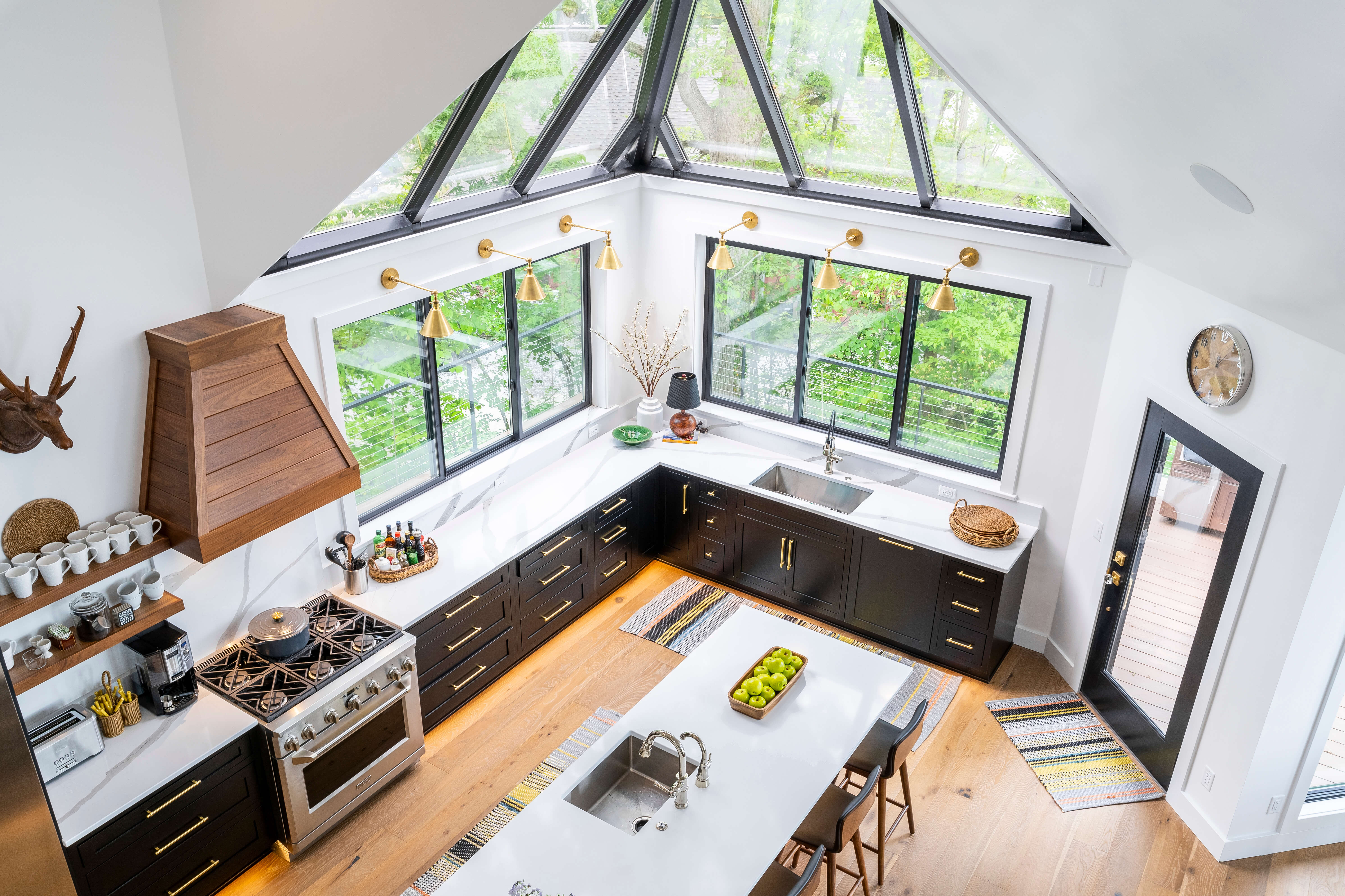 The top view of the black and white kitchen with bright white walls and dark black cabinets with white counters.