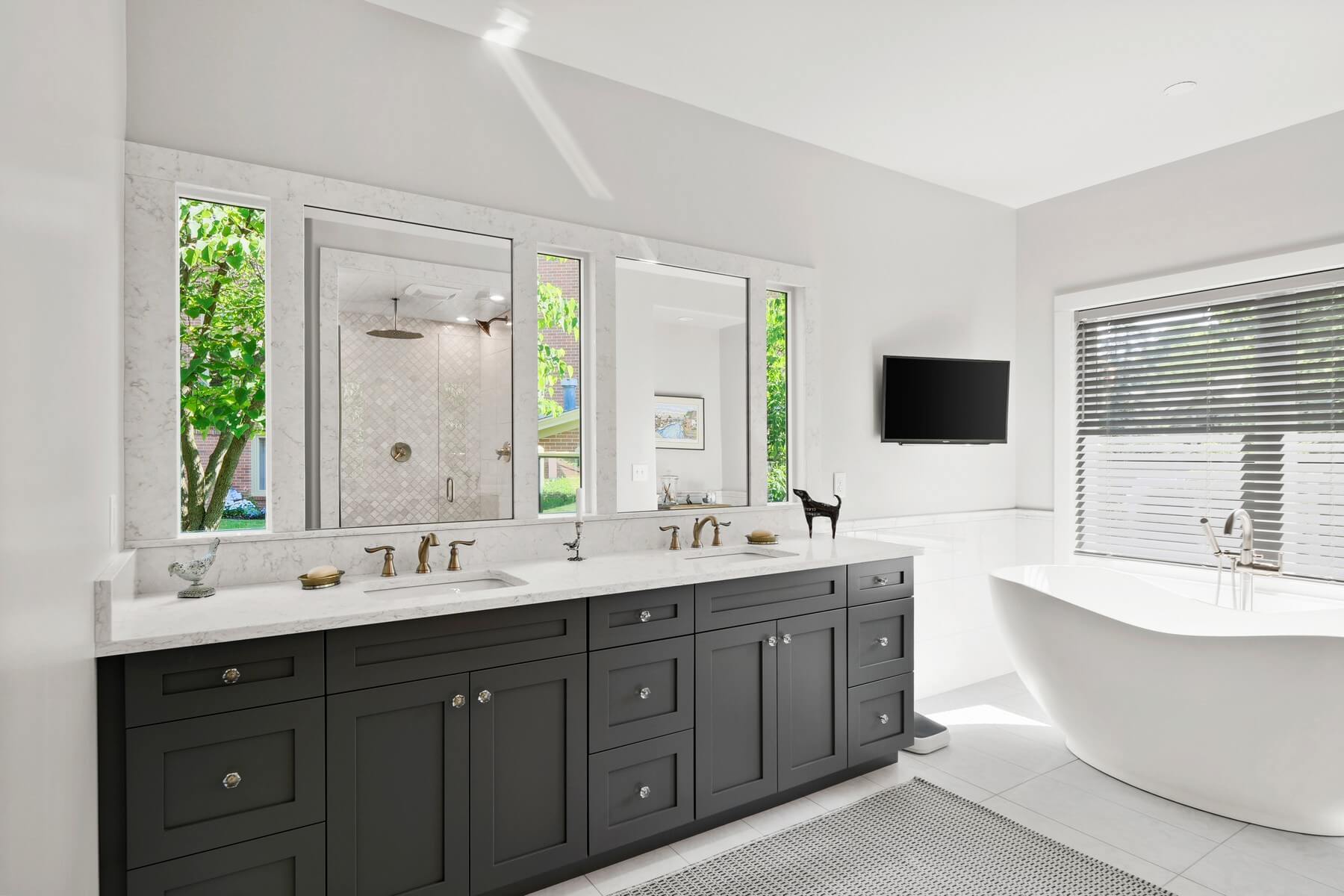 A master bathroom designed for two with a dark gray vanity with double sinks.