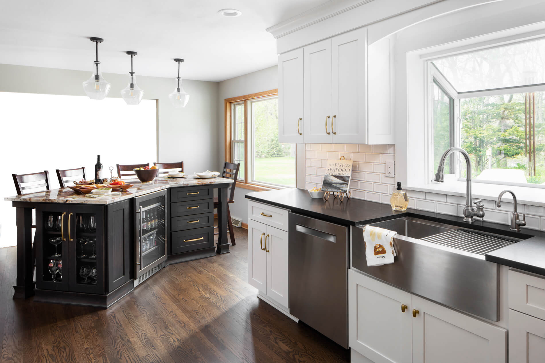 A black, white, and gold kitchen with an angled kitchen island.