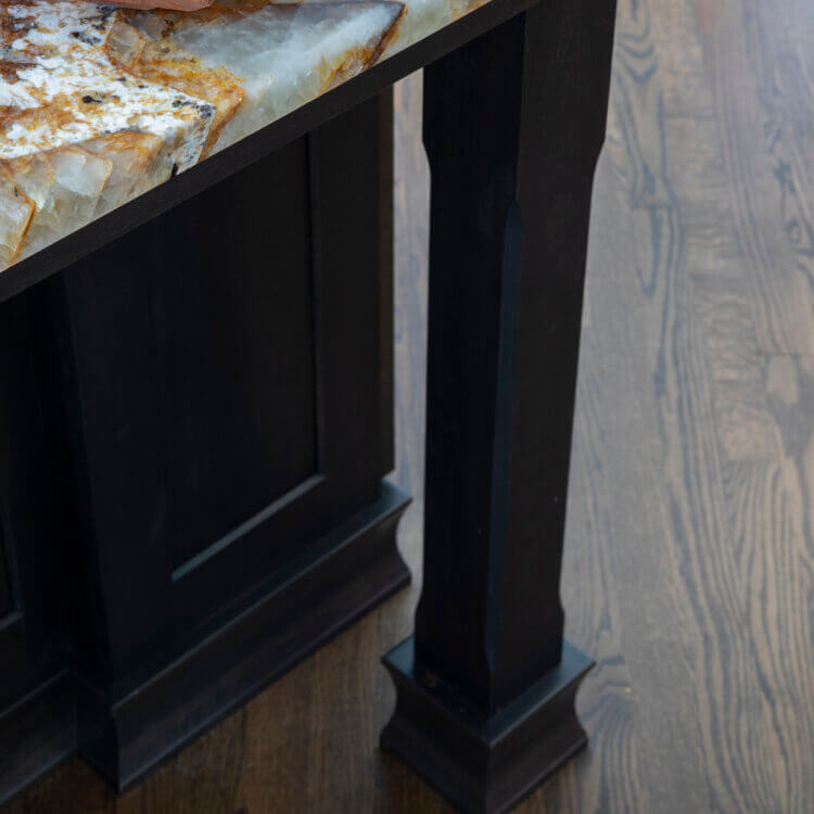 A kitchen island with a decorative post in a dark color.