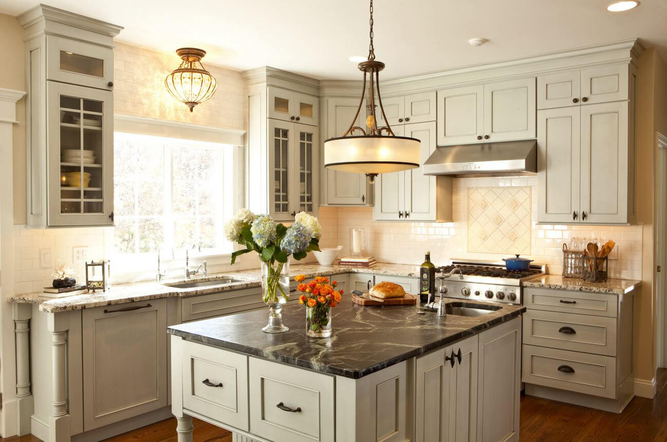 A classic farmhouse styled kitchen with off-white painted cabinets and a furniture style kitchen island featuring mullion glass cabinet doors.