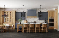 A modern English styled kitchen design with dark navy blue and light stained cherry wood cabinets.