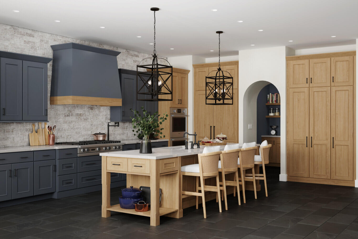 An old Englishh style kitchen design with deep dark navy blue painted cabinets contrasted by light stained cherry wood cabinets. The modern wood hood makes for a stunning focal point with the two toned paint and stain colors. The Dura Supreme kitchen island is a multi-functional workspace with countertop seating for four guests.