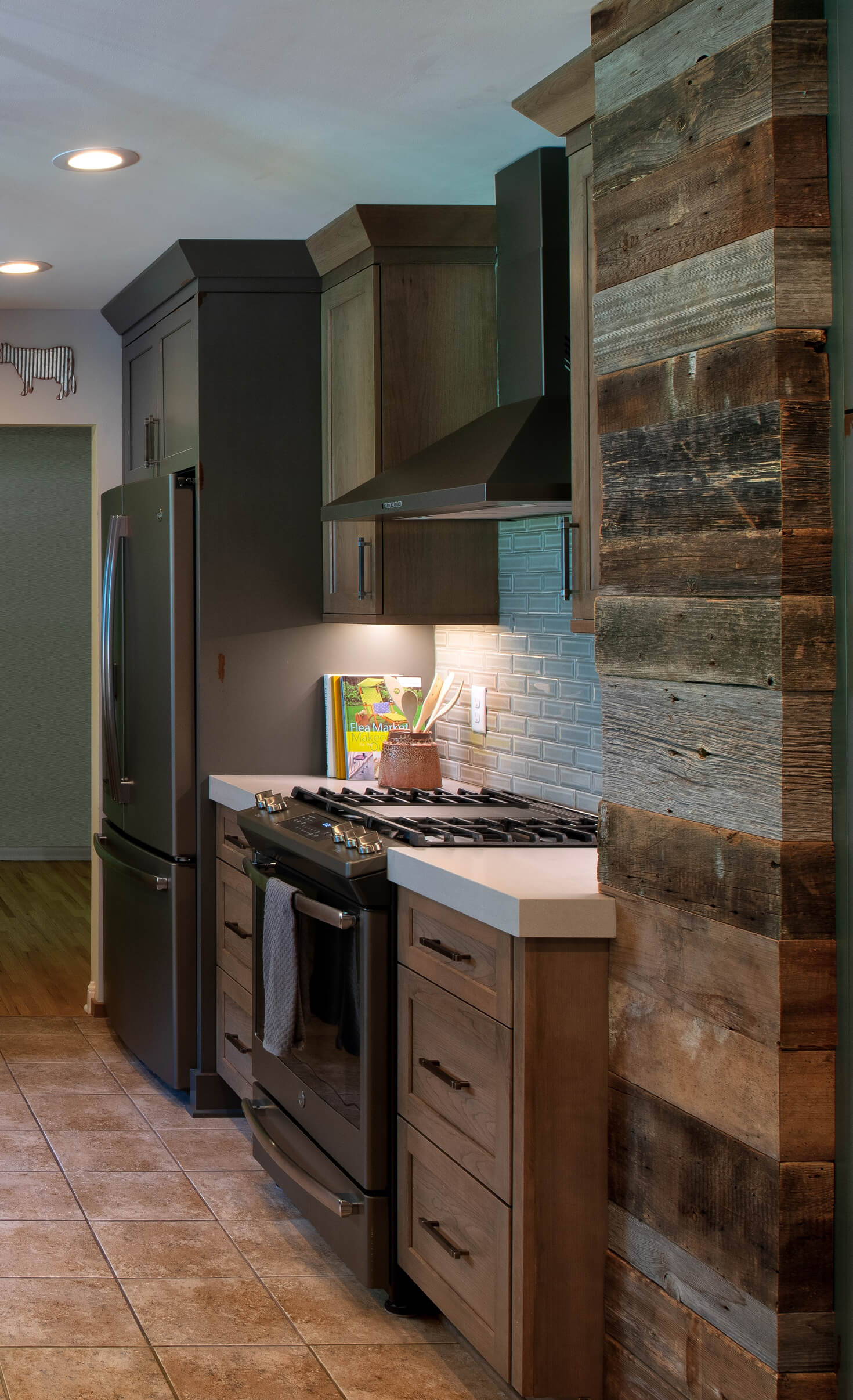 A stunning industial style kitchen dseing with wood cabinets and distressed painted cabinets with a rustic look.