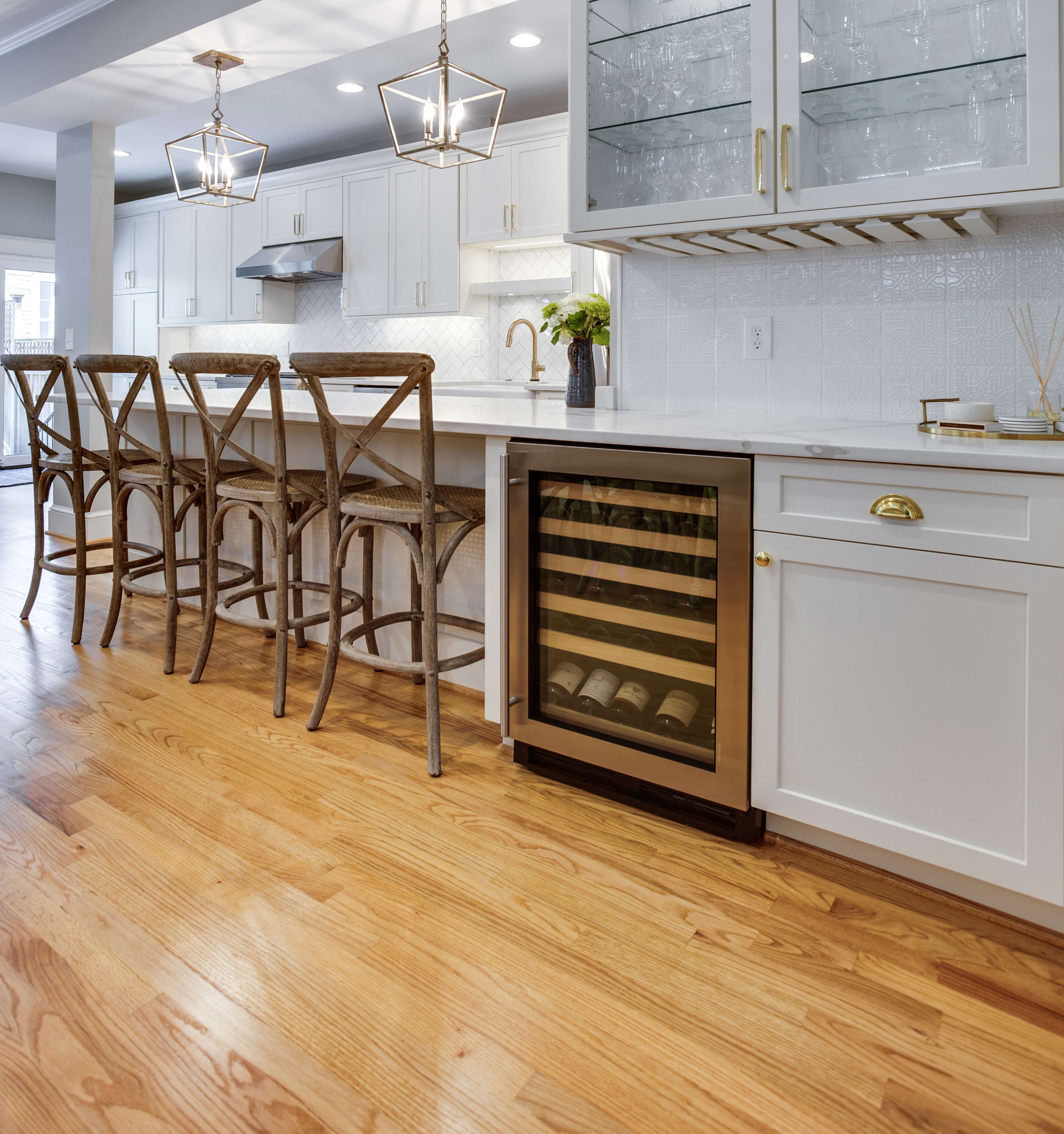 Natural wood floors in a remodeled kitchen with beautiful white painted shaker cabinets.