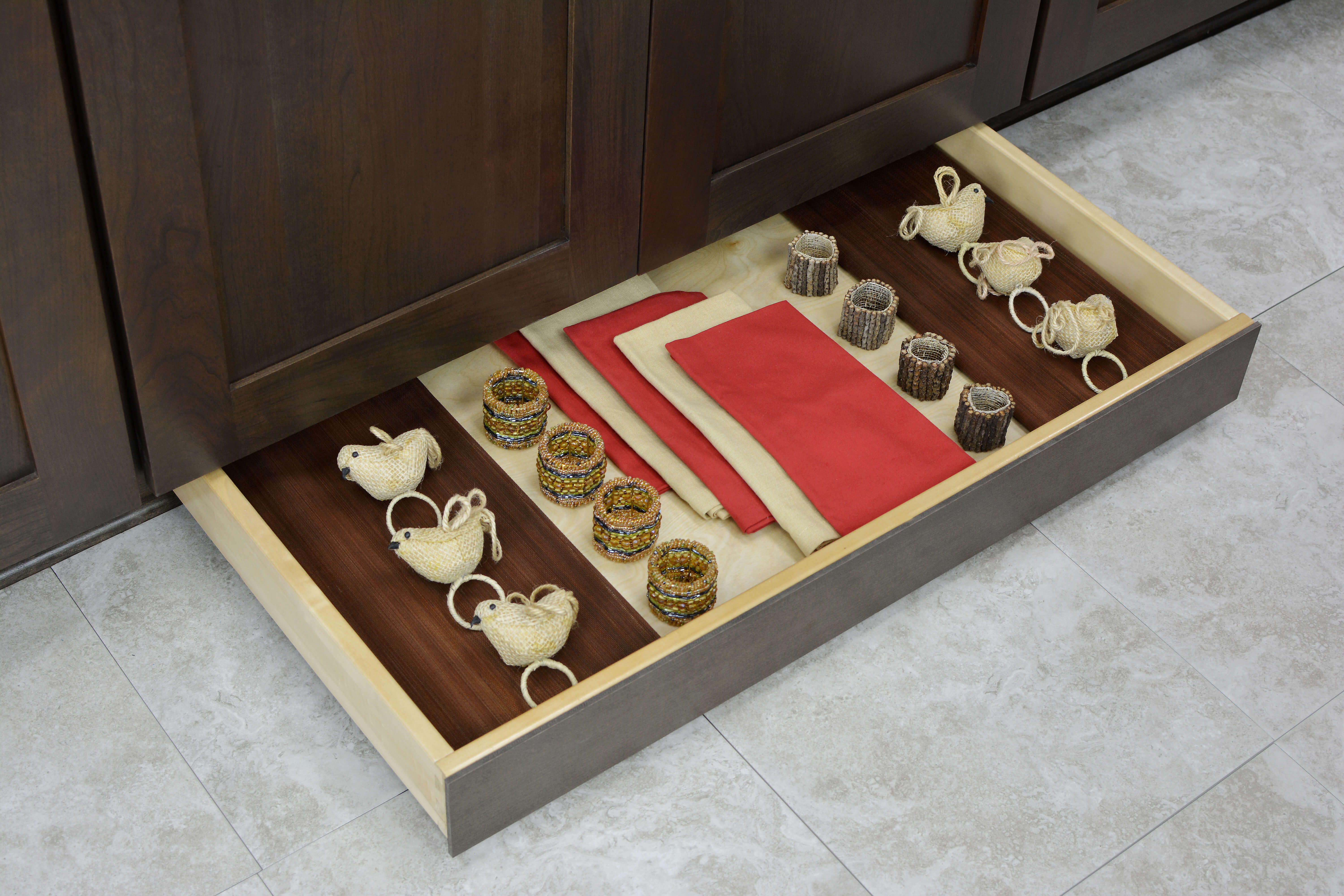 A hidden toe kick drawer with extra storage for seasonal napkins and tableware.