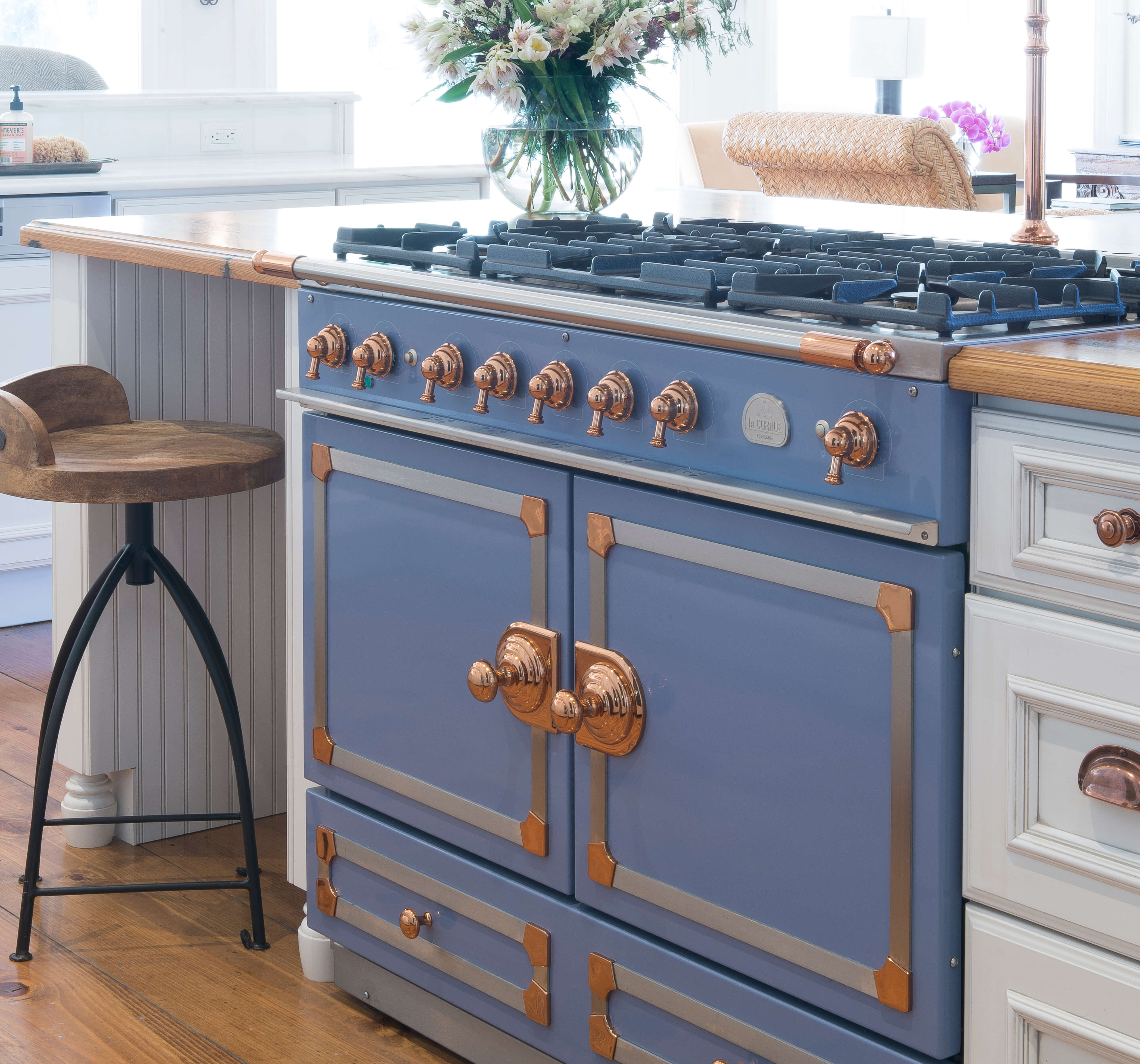 A French style periwinkle oven with traditional styled white painted cabinets from Dura Supreme Cabinetry.