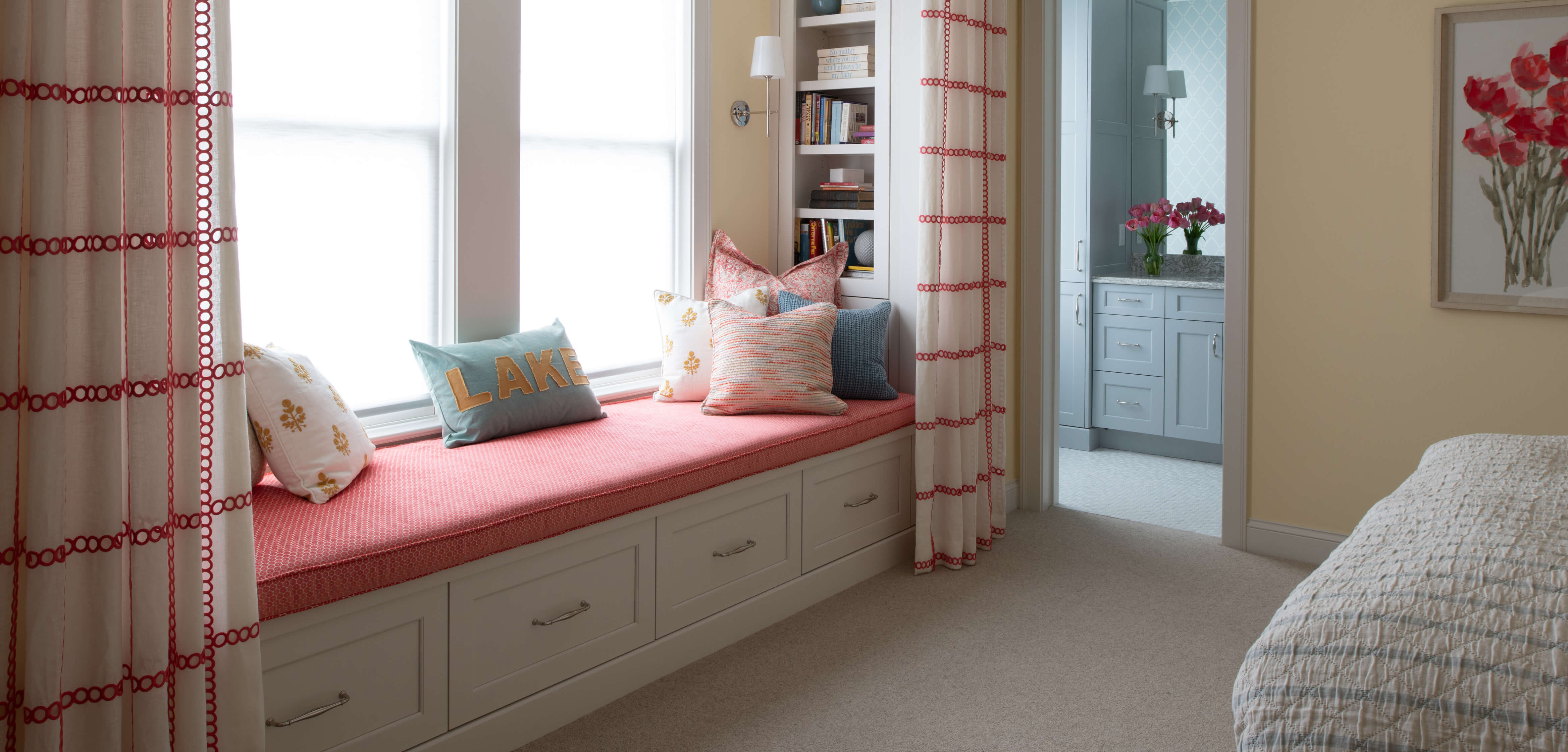 Daughter's bedroom and bath with a built-in window nook with boot bench seating and an open book shelf for books and decor.