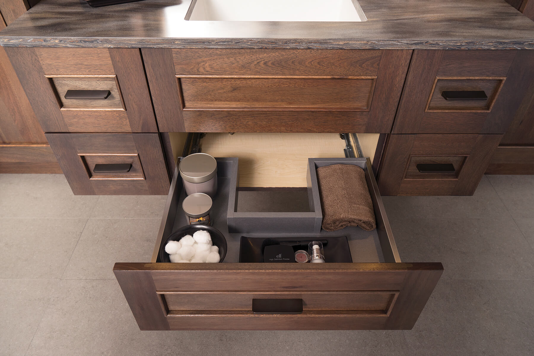 A stainless steel plumbing drawer on a floating vanity cabinet designed to add accessible storage around the plumbing fixtures right below the bathroom sink. This is a great modern cabinet storage solution and is easy to clean.