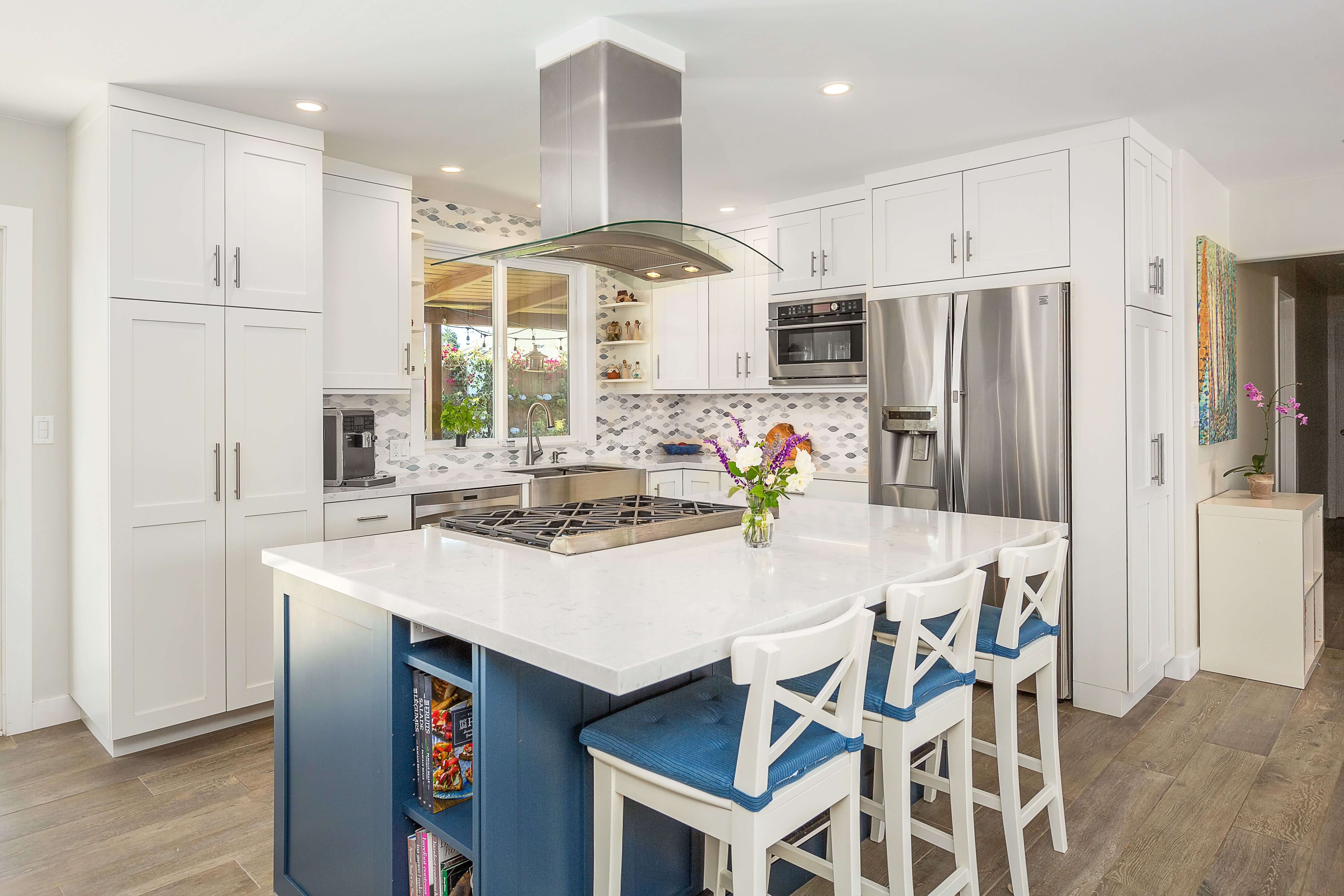 A white and blue kitchen design with a navy blue kitchen island.