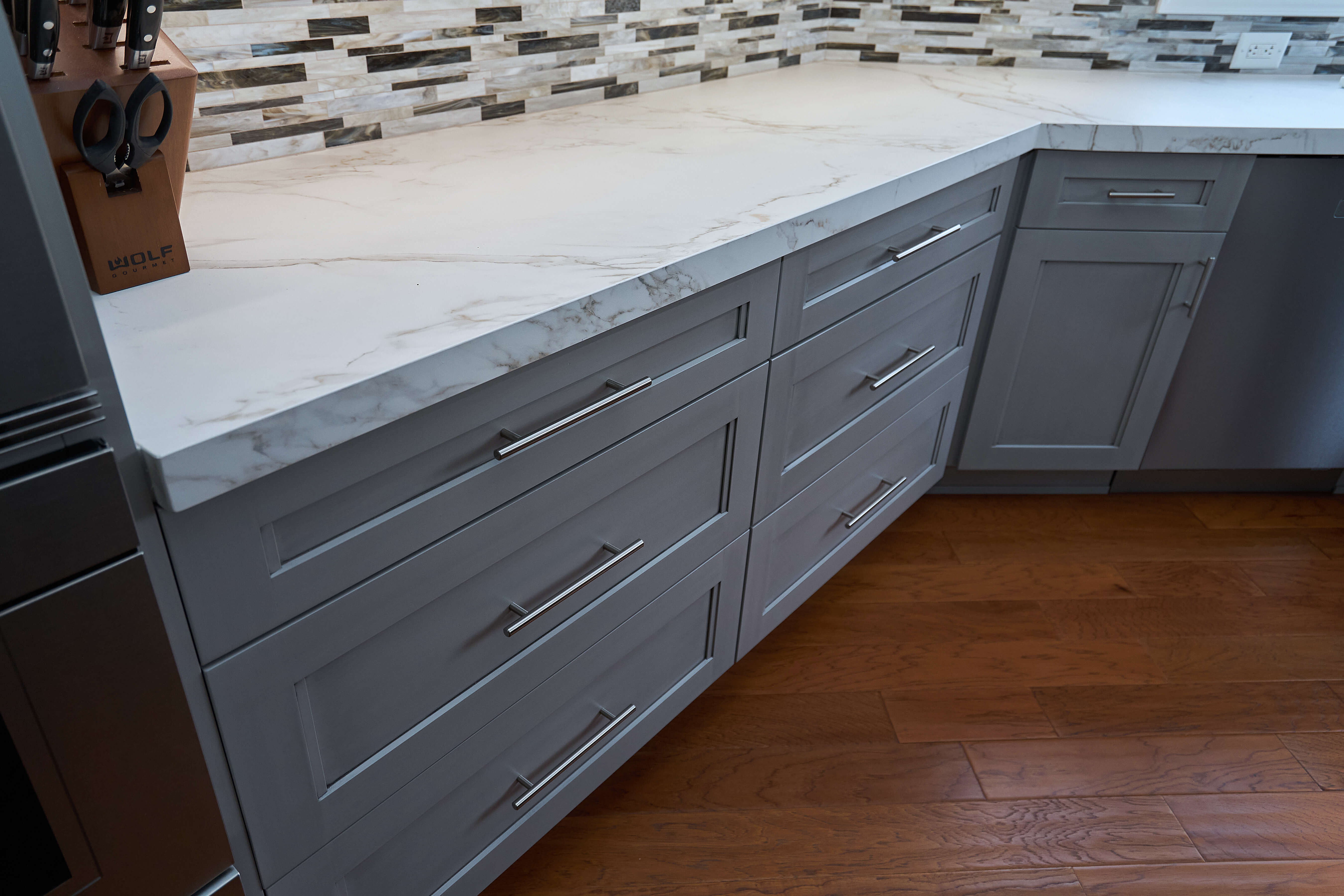 A close up of the gray painted base cabinets in a transitional styled kitchen.