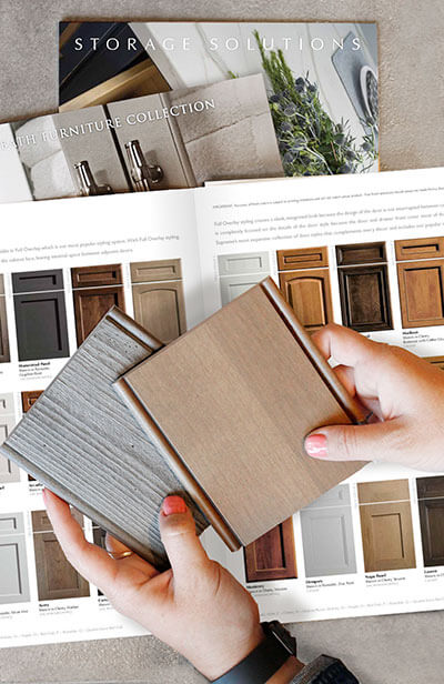 Become a cabinetry dealer for a premium semi-custom and custom kitchen cabinet brand. A close up of a cabinet designer holding samples of cabinet finishes.