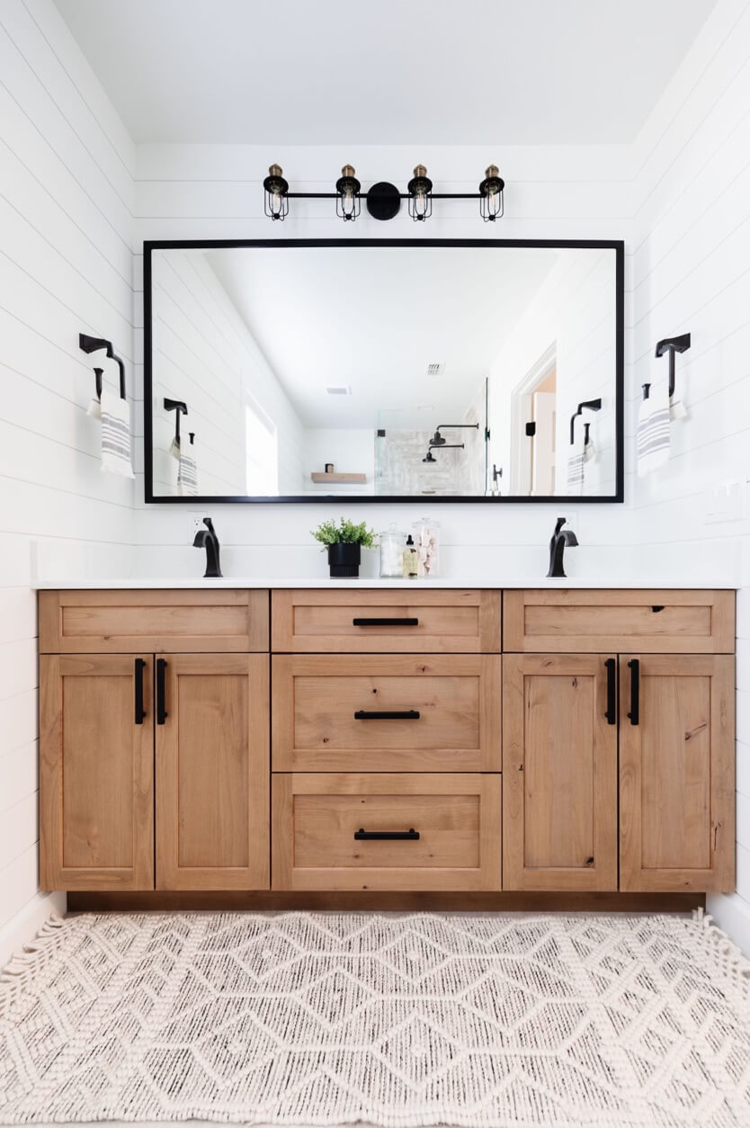 A naturally stained, light wood, bathroom vanity with black accents.