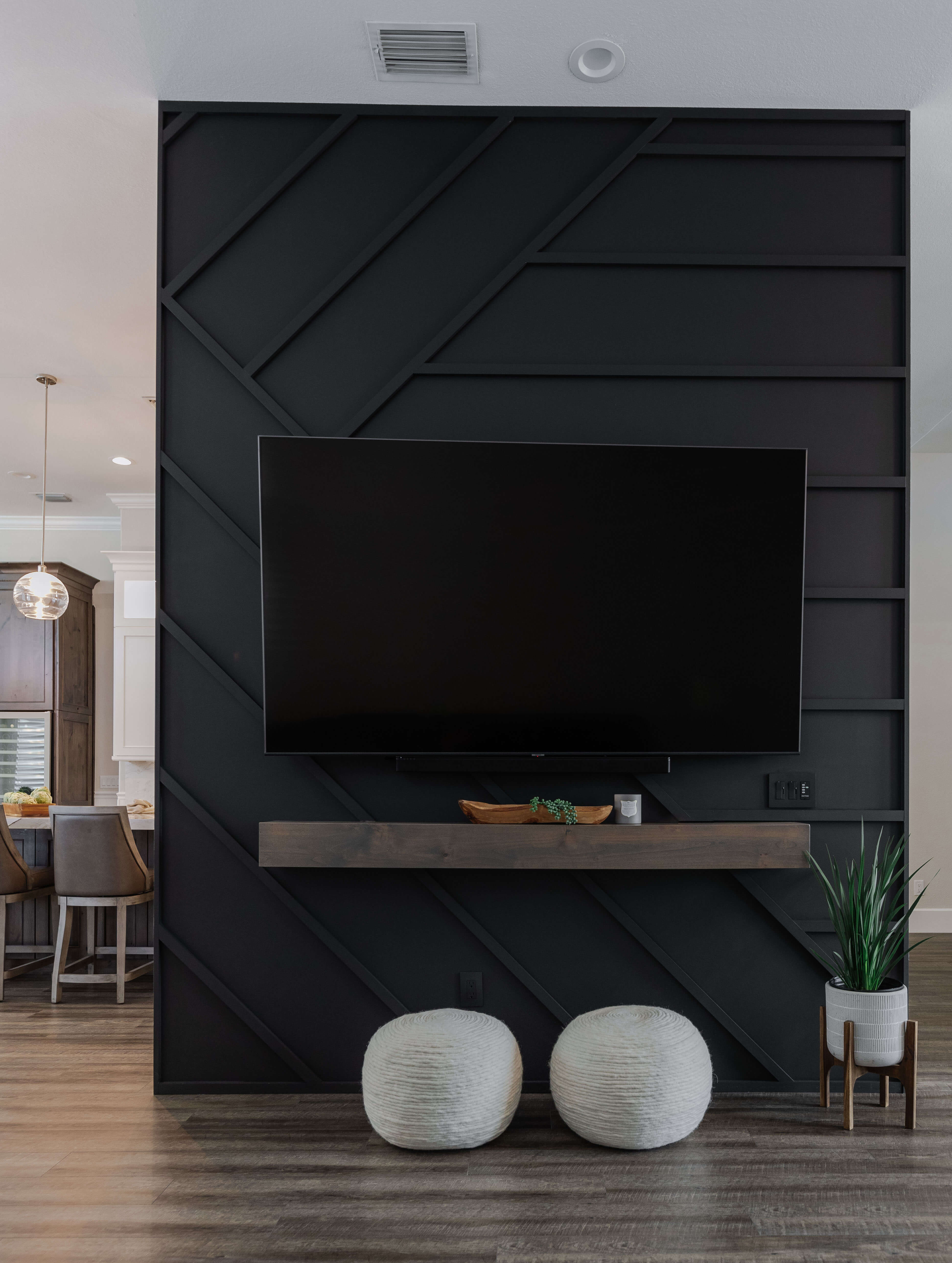 The Tv wall deviding the kitchen and the living room was accented with black painted with a unique modern pattern.