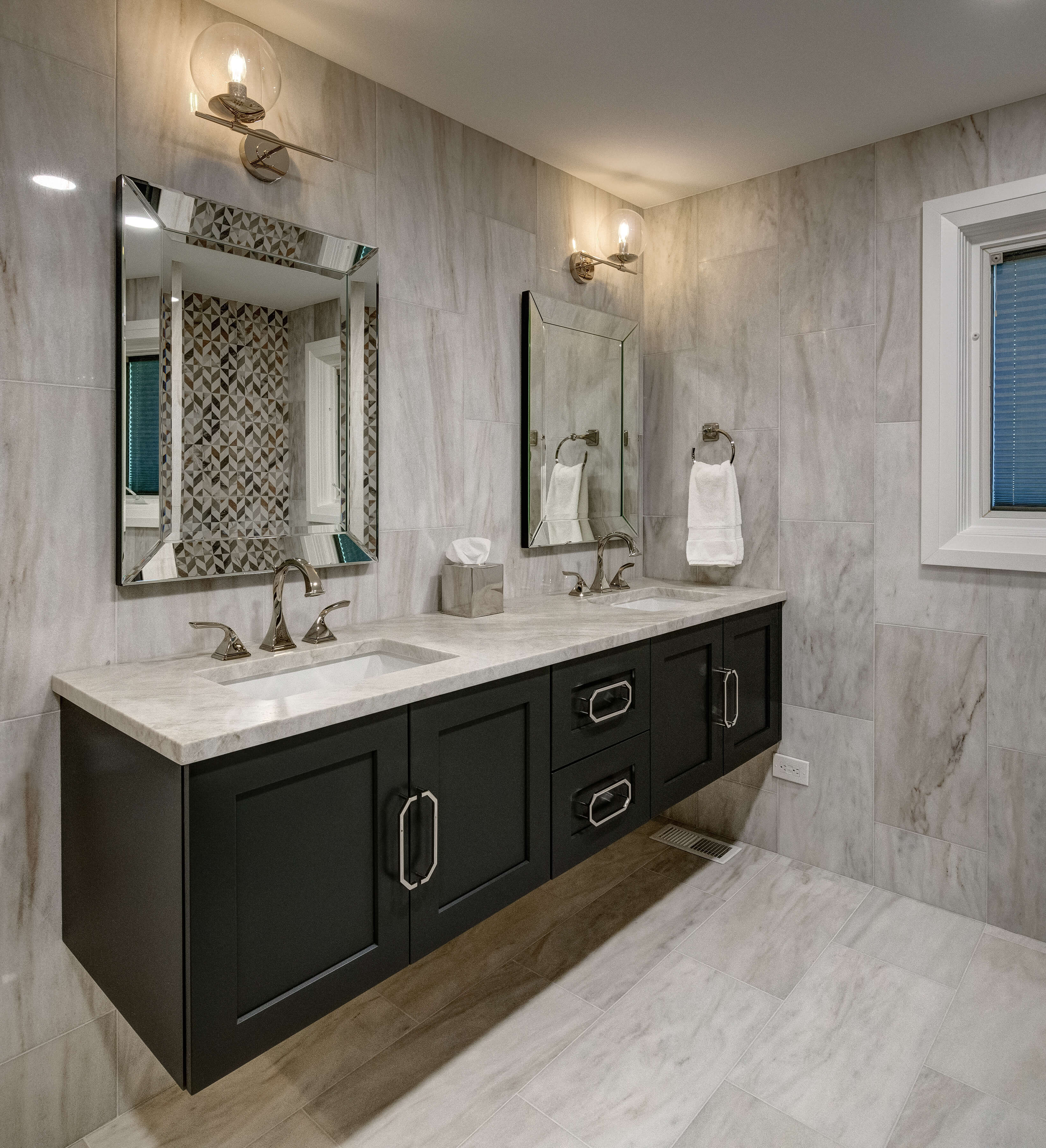 A transitional styled bathroom vanity with flat panel doors in a master bathroom design with a gray color palette.